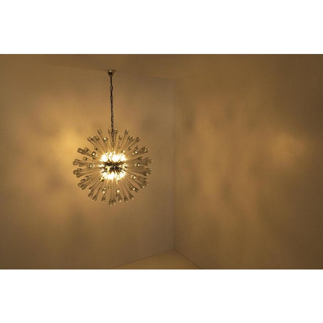 Elegant sputnik chandelier with transparent Murano glass drops attached to a metal sphere from the 1960s. This striking...