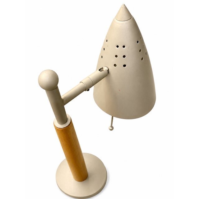 Striking Mid-Century Modern hardwood table lamp featuring a sculptural silhouette and distinctive conical-shaped shade....