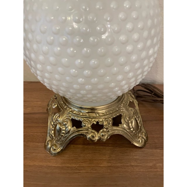 Table lamp with white milk glass globe (top globe is missing). It measures 21-1/4" tall (if the top globe is added) x...