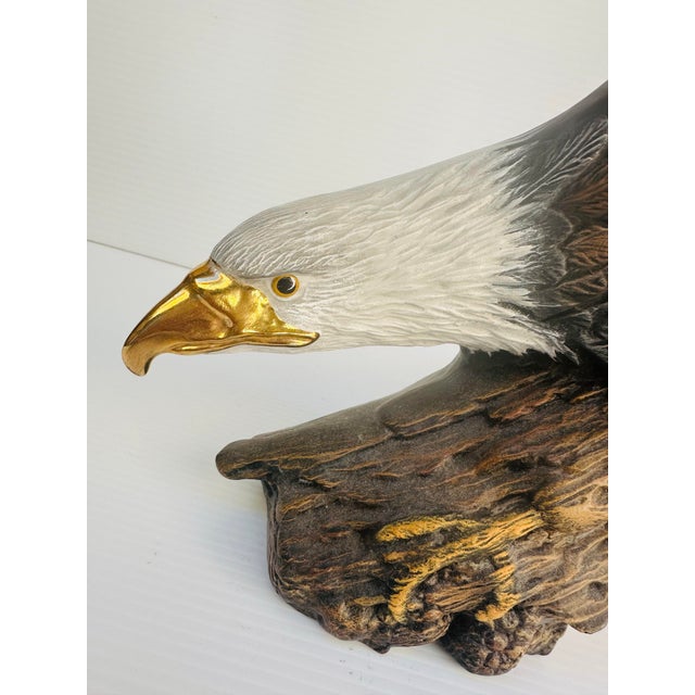 A vintage porcelain bald eagle figurine standing approximately 12 inches tall, beautifully hand-painted in rich natural...