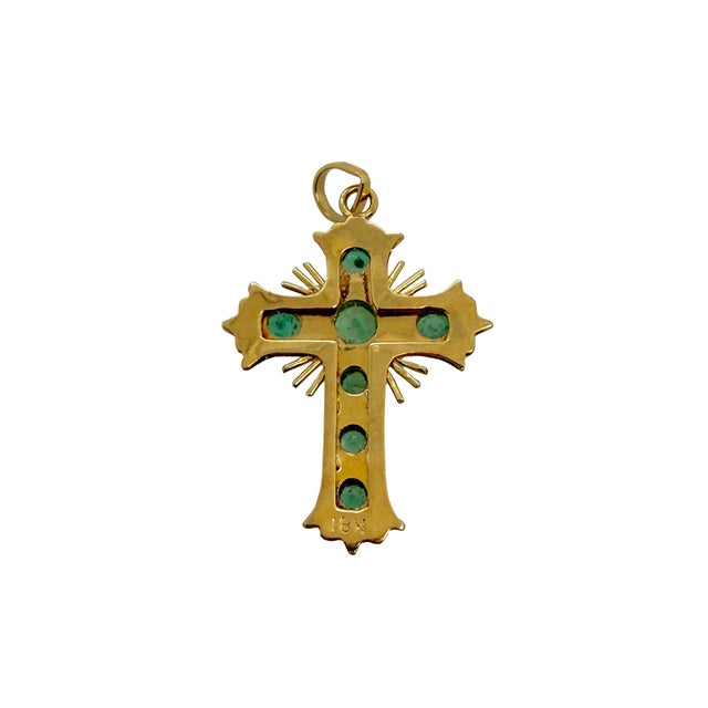 A beautifully crafted vintage 14K gold Latin cross pendant set with seven natural round emeralds. Each emerald is...
