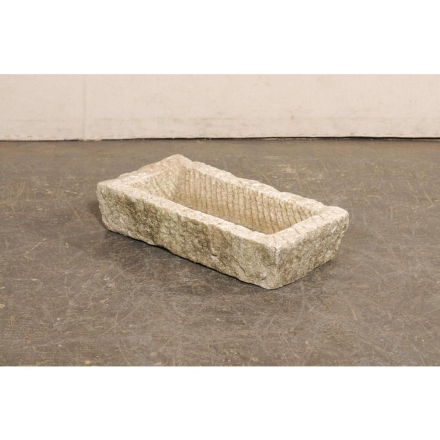 A Spanish carved stone basin or planter from the 19th century. This antique trough from Spain, has a rectangular shape...