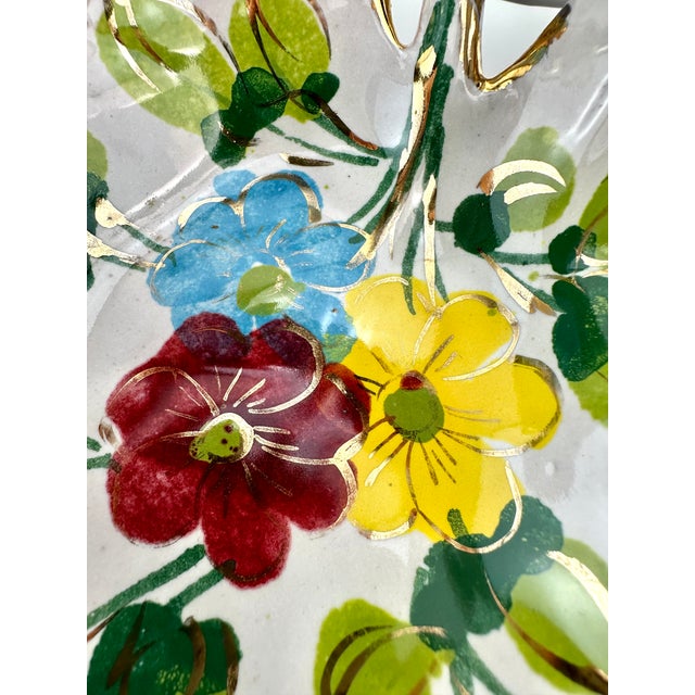 This Mid Century decorative dish boasts a hand-painted floral design, complete with a whimsical blue bow that gives the...