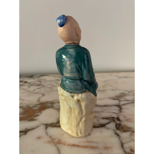 Lovely seated man in a colorful robe with a fish and basket. All meticulously hand painted. The basket has an opening that...