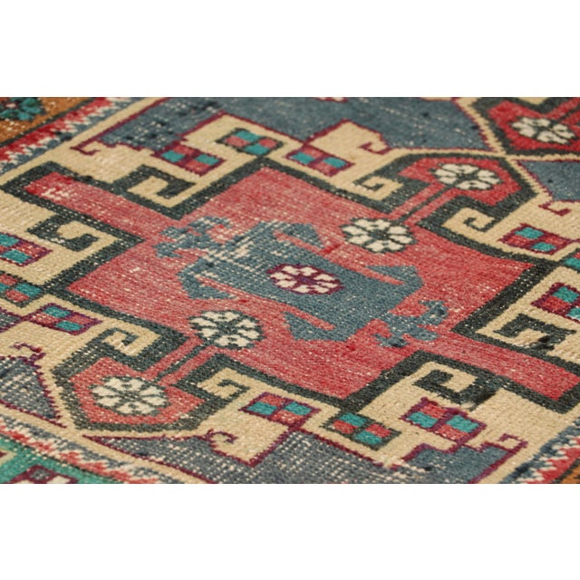 Hand-knotted in wool, originating from Turkey circa 1950-1960, this 2x3 vintage gift-sized rug is one of a very special...