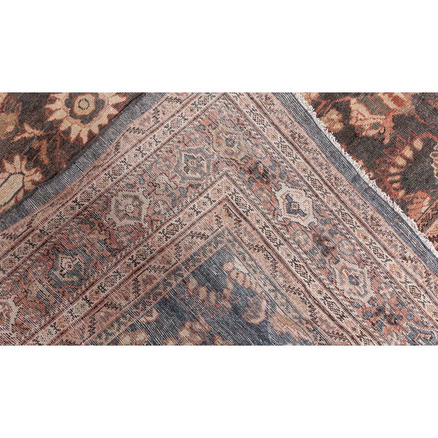 An early 20th century Persian Sultanabad carpet, the brown field with a symmetrical pattern of flowing stylized leaves and...