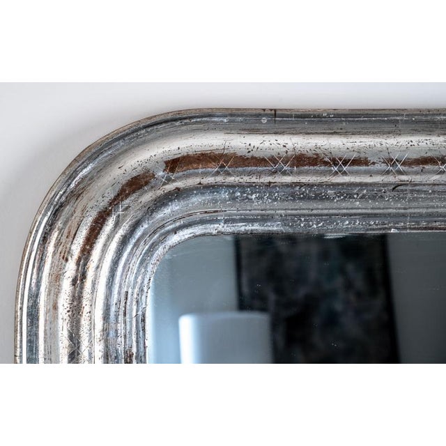 An authentic Louis Philippe mirror featuring a carved wood frame and curved top corners. This item was sourced directly...