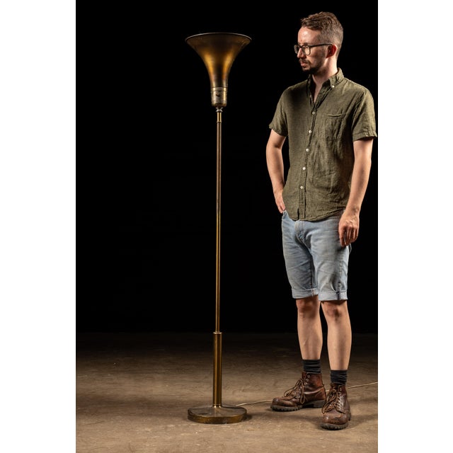 Vintage all-brass torchiere floor lamp featuring a tall, slender column and an inverted pyramidal or flared trumpet-form...