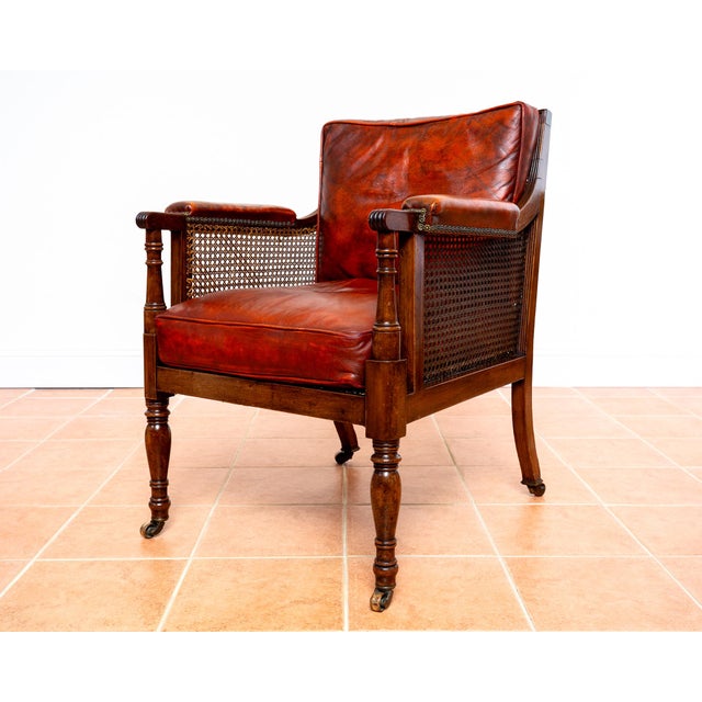 A gorgeous, fine and extremely rare mahogany and leather Regency bergere library armchair in fabulous antique condition....