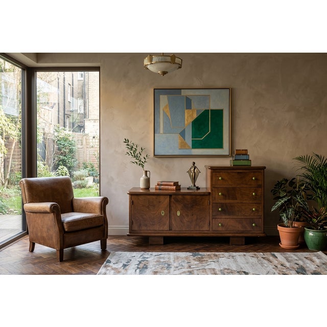 A beautifully restored Art Deco sideboard in rich walnut. This piece features a distinct asymmetrical stepped silhouette,...