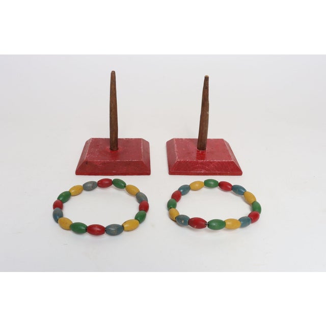 Pair of handmade Folk Art ring toss games, ca. 1950s, USA. Composed of whittled tree branches supported by red painted...