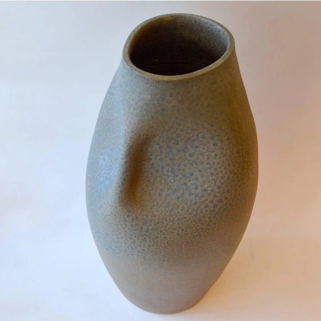 This large hand thrown and hand formed vase features a subtle blue glaze.