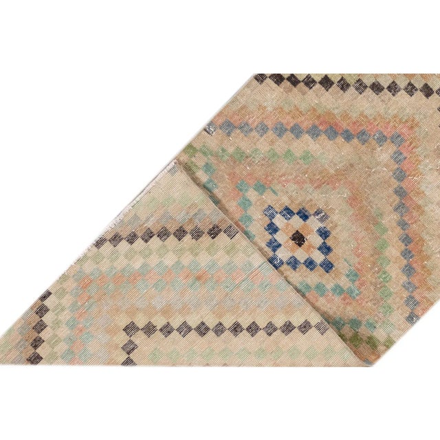 Beautiful vintage Turkish hand-knotted wool runner with a beige field. This rug has multicolor accents in an all-over...