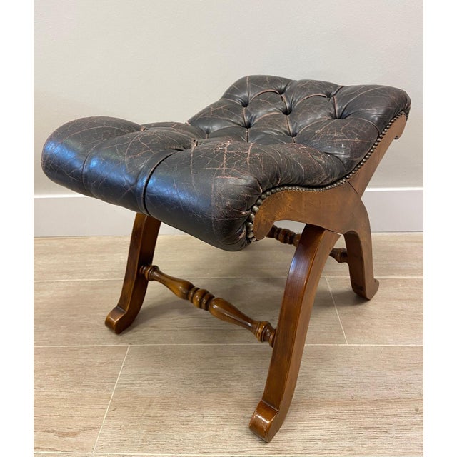 Wonderful Escabel with wood structure and brown leather seat, made in the 70s. It presents double curvature legs, in the...