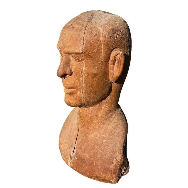 A striking mid-20th-century hand-carved wooden bust, depicting the head and upper torso of a man rendered in a raw,...