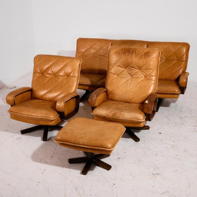 Leather sofa set from the 1970s. The set consists of a three-seater sofa, two armchairs, and a footrest. The frame is made...