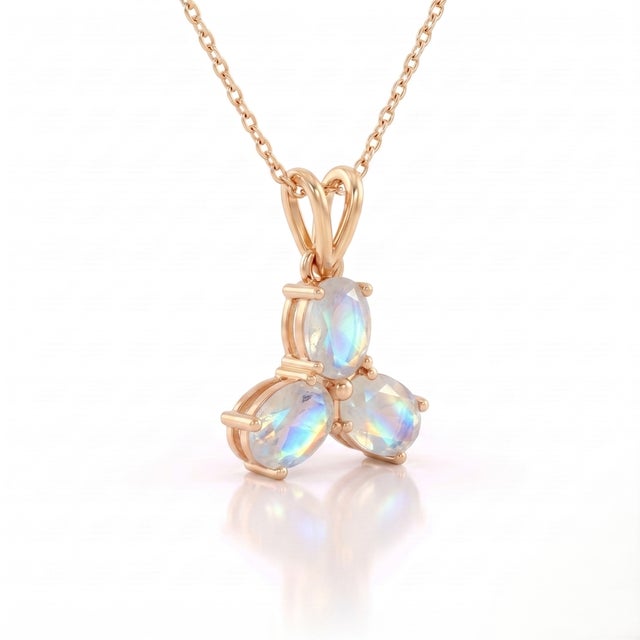 An ethereal three-stone design featuring oval-cut natural moonstones arranged in a graceful trefoil formation, secured in...