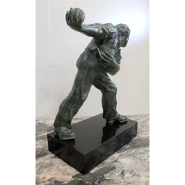 Bronze with Green Patina, dating from the beginning of the last century, representing a man in a throwing position.This...