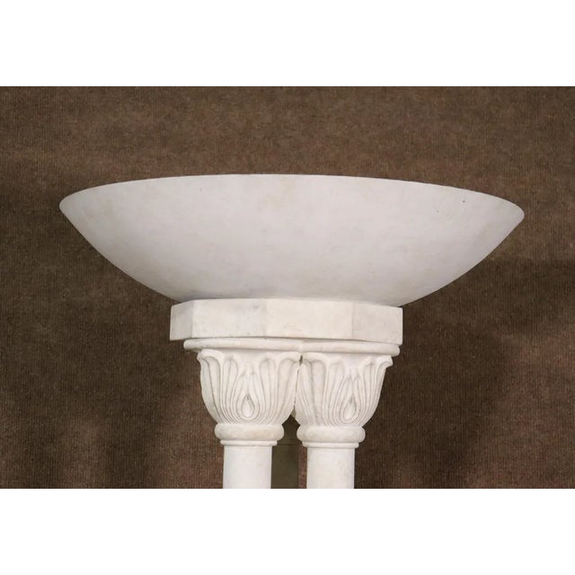 This pair of torchierre lamps feature sculpted marble style motif with three pillars holding an uplight shade. SKU:...