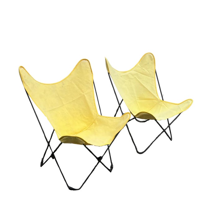 Offering a pair of circa-1950 butterfly chairs with slightly mismatched frames, but the same size canvas sling seats...