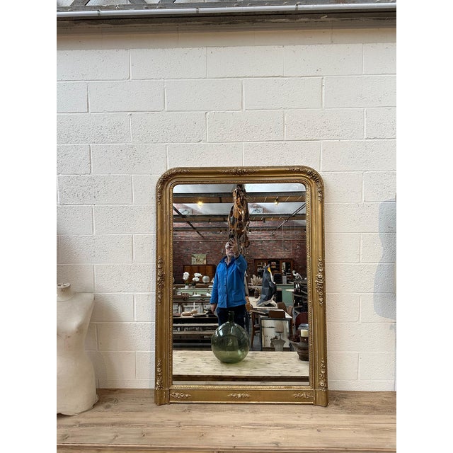 This large 19th-century mirror has been fully restored. It features a gilded frame with a patina finish, adorned with...