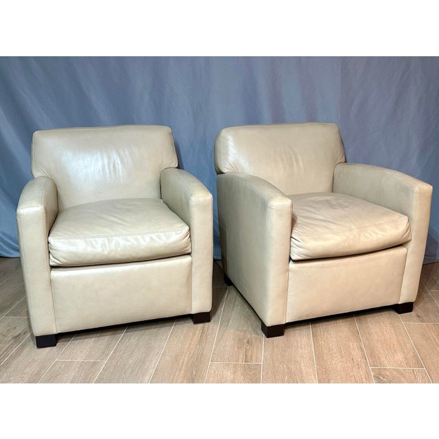 A sophisticated pair of cream leather club chairs by A. Rudin Furniture Company, known for exceptional American...