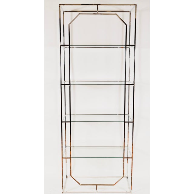Modern Chrome and Glass Etagere stands as a sleek statement of style and functionality. Boasting four glass shelves held...