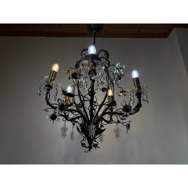 A large-scale vintage chandelier from the 1990s, crafted with a wrought iron body and adorned with delicate ivy and leaf...