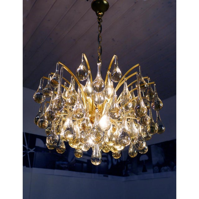 Elegant teardrop chandelier made of clear murano glass drops mounted on a gilt-brass frame. Chandelier illuminates...