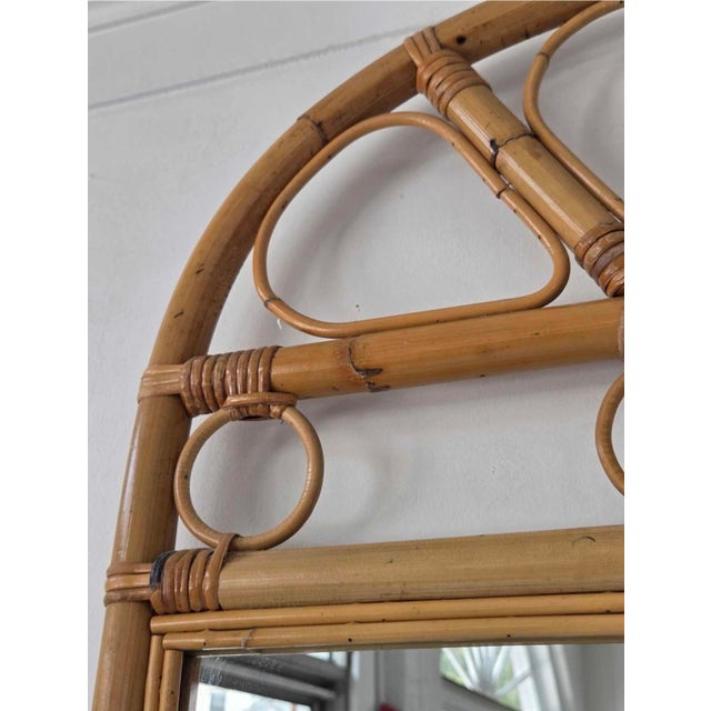 Charming vintage wall mirror with a natural bentwood rattan frame and decorative arched pediment. The openwork crest...