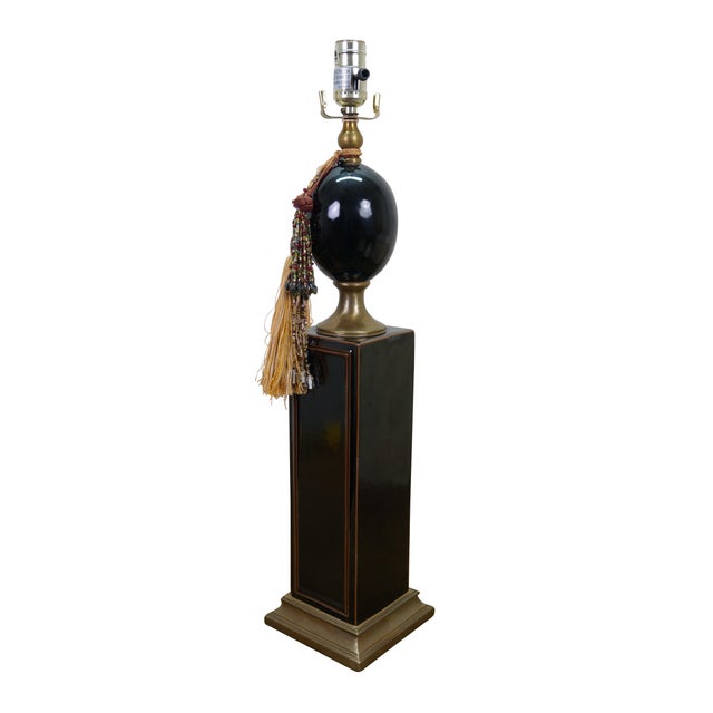 Mid century table lamp by Maison Le Dauphin. Made of porcelain and brass featuring a rectangular column that supports an...