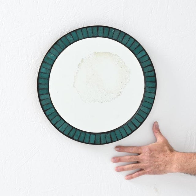 We date this delicate mirror between 1960s to 1970s. Around the frame, it features inlaid glass ceramic tiles in an...