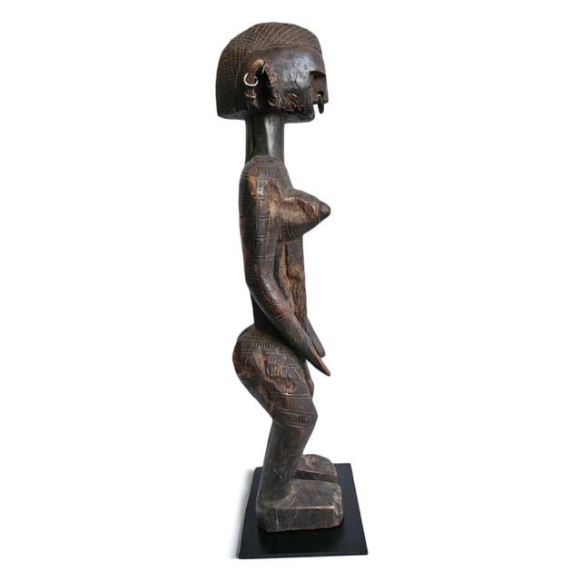 Original carved wood Bambara female figure on iron stand. Intricate traditional carved patterns and details....