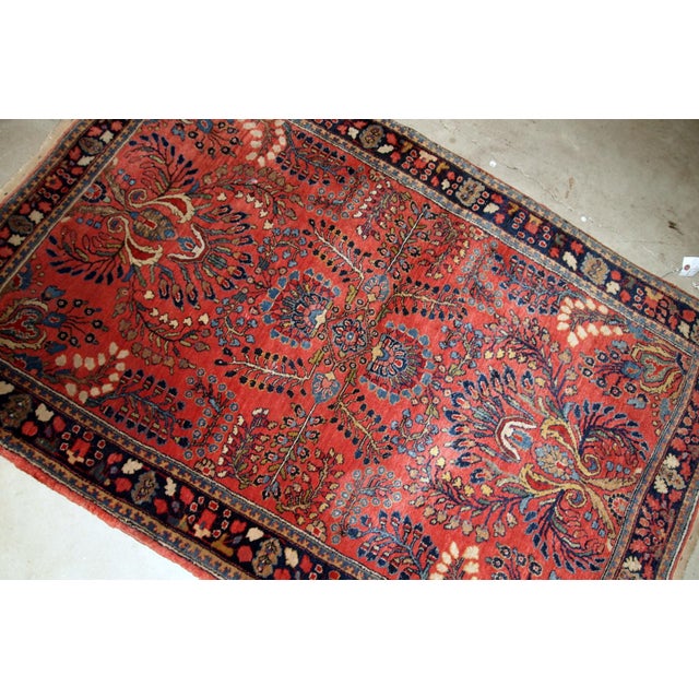 Handmade antique Sarouk rug in red color. The rug is from the beginning of 20th century in original good condition....