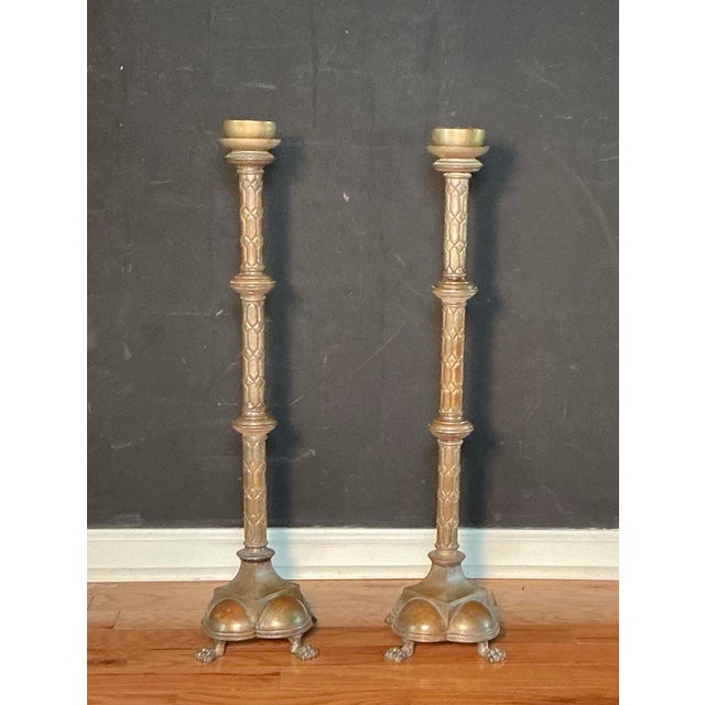 Antique pair of 29" tall solid brass candlestick holders, likely dating from the 18th or 19th century. Designed to hold...