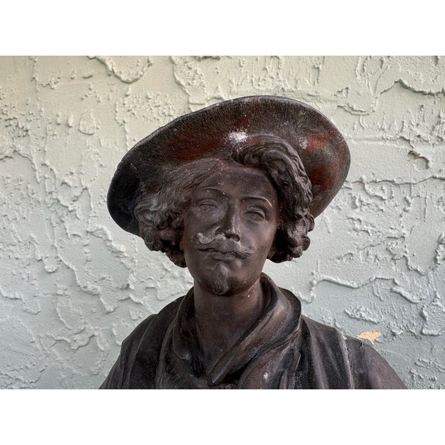 This impressive antique French figural sculpture depicts a standing musketeer or cavalier, rendered with expressive...