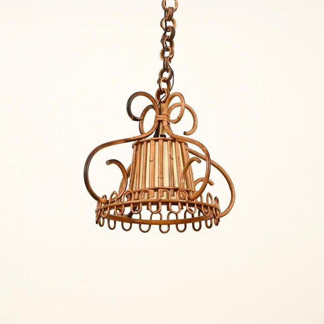 Marvelous and unique mid-century organic pendant entirely hand-crafted in curved rattan, hand-woven wicker and completed...