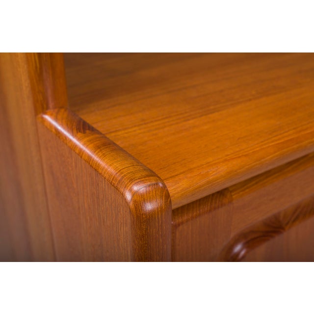 Elegant Danish teak wall cabinet unit by Dyrlund, designed in the 1970s. Featuring four adjustable open shelves above a...