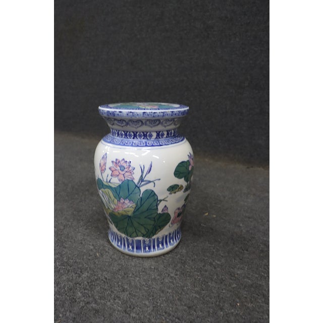 Porcelain vase with hand-painted lotus and foliage design. Classic baluster form with flared rim. Blue and white border...