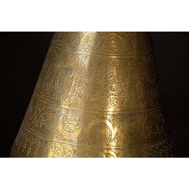 An impressive early 20th-century Islamic brass vase, circa 1920, distinguished by its monumental 28-inch height, elegant...