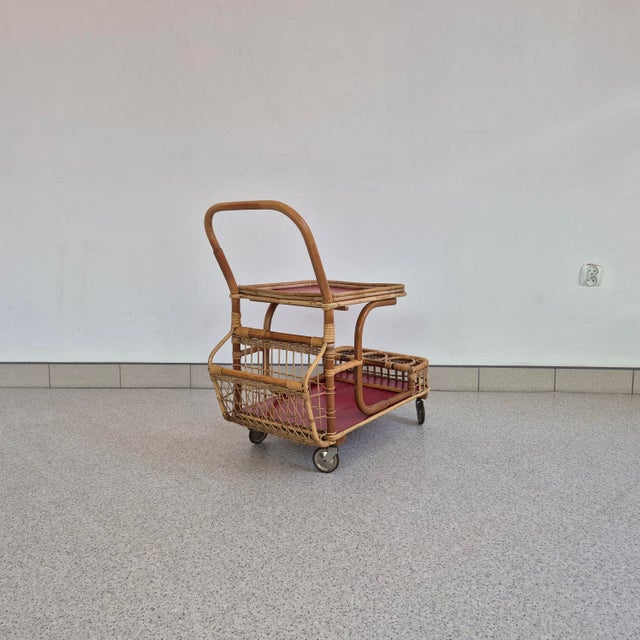Original 1970s bar cart made of bent wicker. The cart features a two-tier construction, with a large upper tray with a...