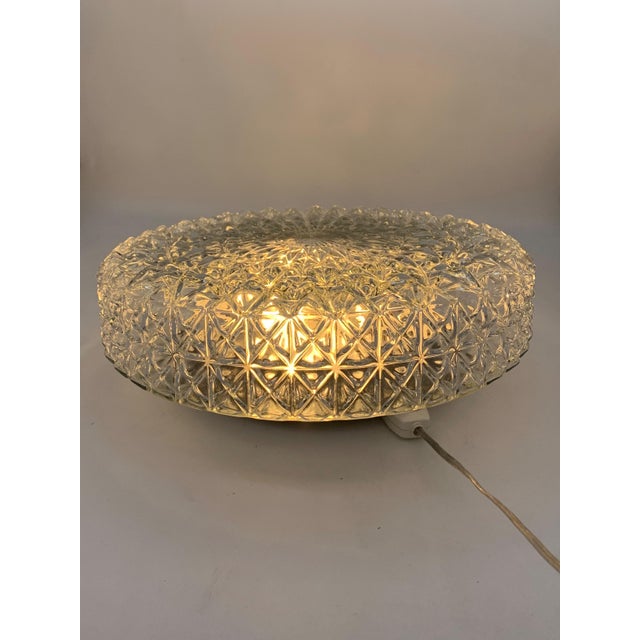 Single ceiling or wall light in clear glass with a refined star-shaped geometric motif, typical of 1960s and 1970s design....