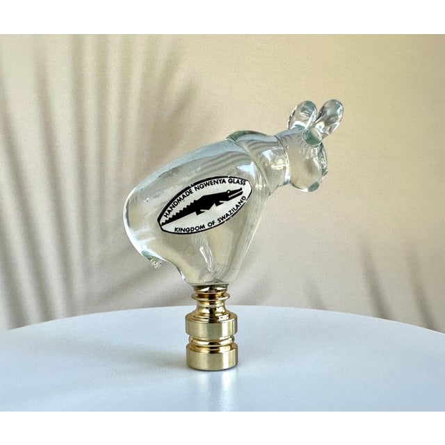 Single lamp finial crafted from a vintage clear glass animal figure from Ngwenya Glass of Swaziland. Sized to fit a...