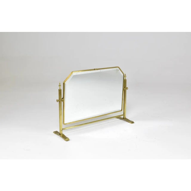 A fantastic French circa 1930s table mirror framed in solid brass, featuring an adjustable tilting mechanism. Its refined...