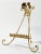 Vintage Italian gilt Tole table easel with ornate base board, curled feet, and intricate floral detail adorning top. Ball...