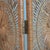 A three panel folding screen in buri rattan, each panel woven with three sunburst medallions that filter light...