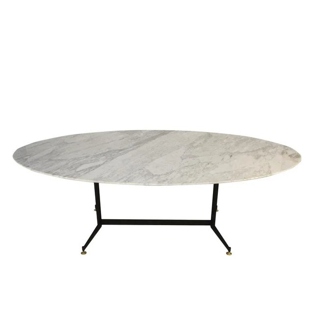 Italian mid-century modern oval dining table from the 1950's. The table is made up of a metallic foot with four legs...