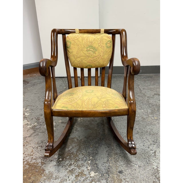 Design Plus Gallery presents a Vintage Empire Style Wood Rocking Armchair. The sculptural wood frame displays sweeping...