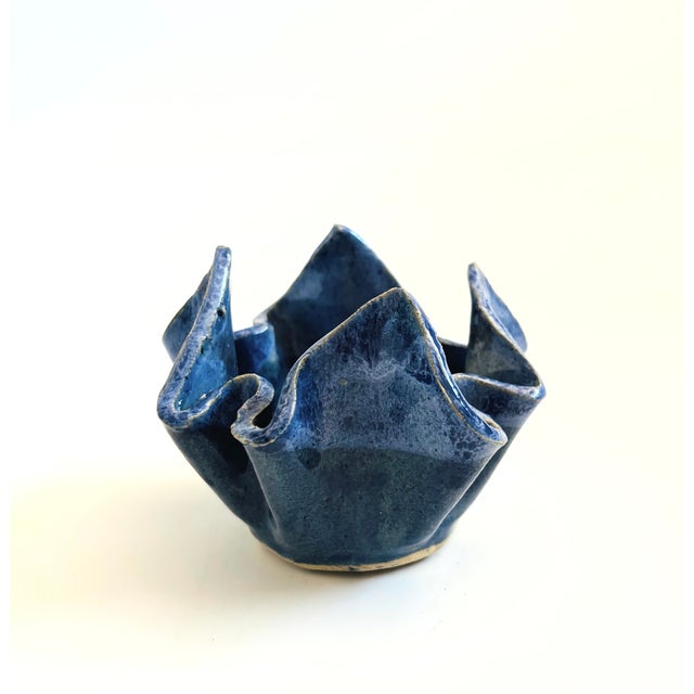 A vintage handmade pottery bowl in a lovely freeform handkerchief shape. Finished in blue glazes. Measures 4.5"W x 3.25"H