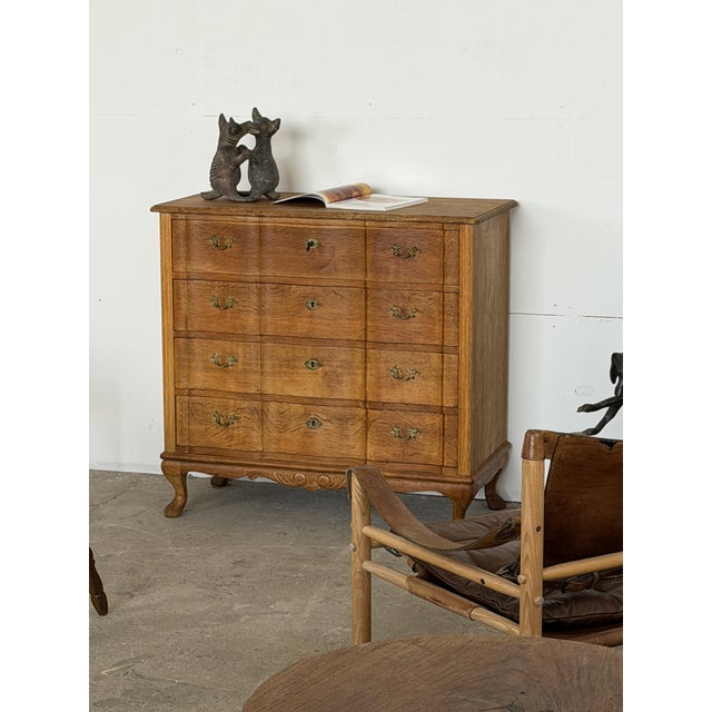 This chest of drawers is Danish production in solid oak, made in the Rococo revival style. It stands on cabriole legs,...